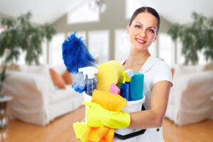 A professional cleaning maid in St. Charles, MO holding a variety of cleaning solutions in a home that requires weekly cleaning services.